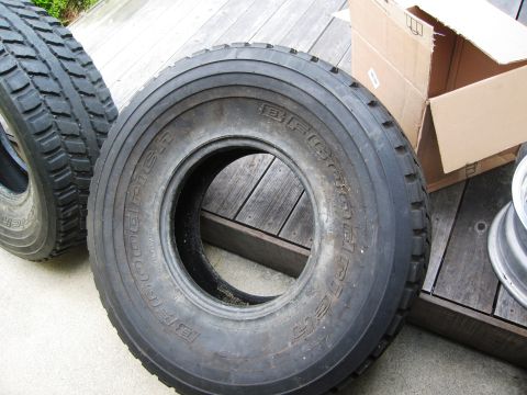 1986 Ford Bronco - A close-up view of a BFGoodrich tire, with another tire and a cardboard box visible in the background.