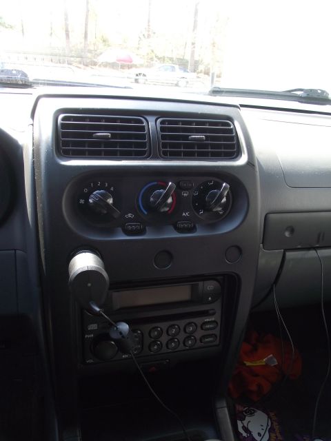 2004 Nissan Xterra - Interior view of a 2004 Nissan Xterra dashboard, showing the center console with climate controls and radio.
