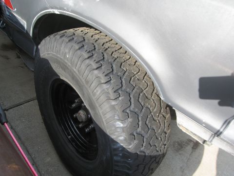 1986 Ford Bronco - Close-up of a silver SUV's fender and tire, BFG All Terrains 315/75/16 tires.