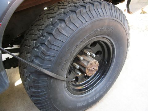 1986 Ford Bronco - A close-up view of a BFGoodrich All-Terrain T/A tire and wheel assembly, showing tread detail and lug nuts.