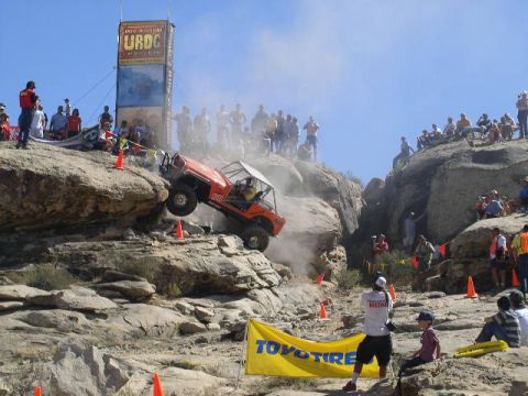 1979 Ford Bronco - Spectators watch an off-road vehicle tackle a challenging rocky terrain during an event.