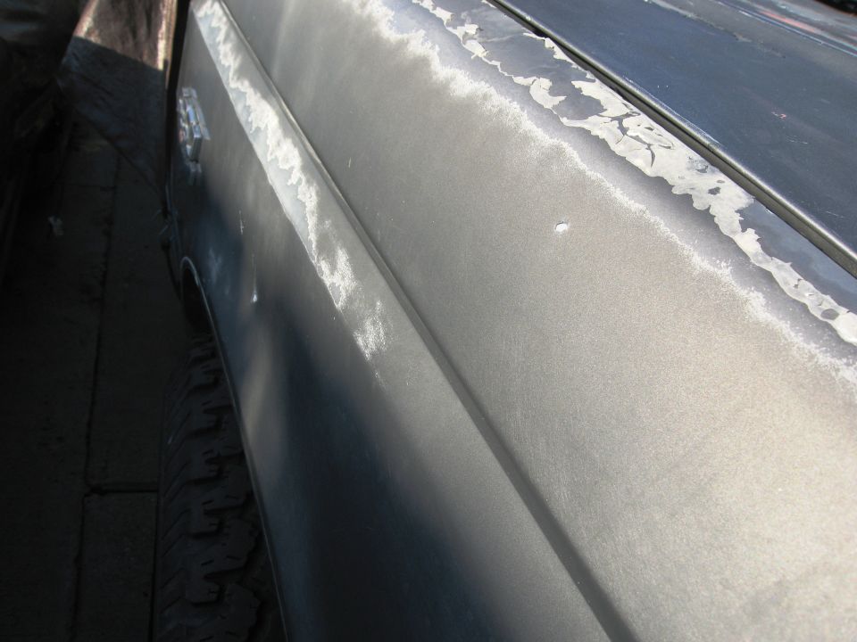 Gray vehicle fender and door with peeling paint