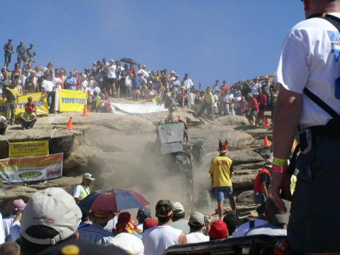 1979 Ford Bronco - A crowd watches an off-road vehicle navigate a challenging rocky terrain during an event.