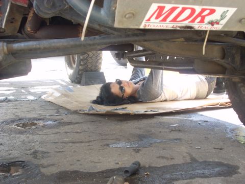 1992 Ford Ranger - Person works on vehicle chassis, with 'MDR Mojave Desert Racing' sticker on frame.