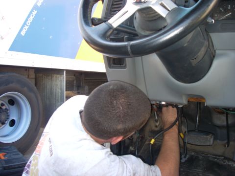 1992 Ford Ranger - Mechanic works on the interior wiring of a vehicle, with the steering wheel visible.