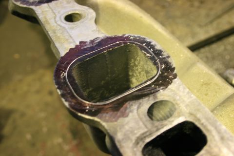 1973 Ford Ranchero - A close-up view of a machined metal engine component, likely an intake manifold, showing a gasket sealing surface.