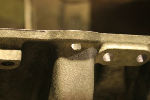1973 Ford Ranchero - A close-up view of a cast metal engine component, possibly an intake manifold, showing mounting holes.