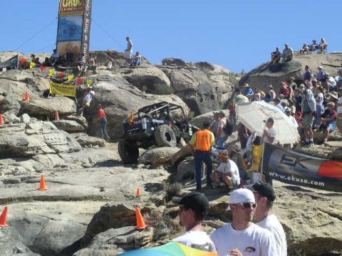 1979 Ford Bronco - Spectators gather to watch an off-road vehicle tackle a challenging rocky terrain during an event.