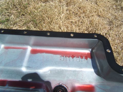 1988 Ford Bronco - A transmission pan with a gasket and "METALLIC" stamped into the metal. Red fluid is visible inside.