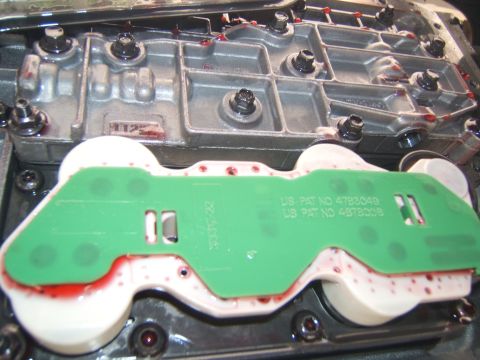1988 Ford Bronco - Close-up of an automatic transmission valve body, showing internal components and red fluid.