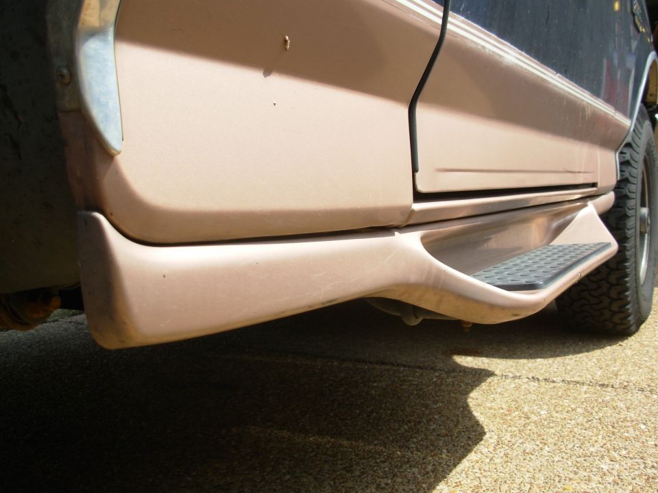 Side rocker panel and running board step of a tan SUV or truck
