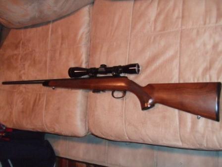 1996 Ford Bronco - A hunting rifle with a scope is shown on a couch.