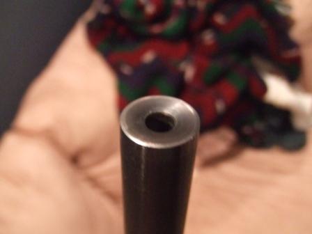 1996 Ford Bronco - A close-up view of a metal tube's opening, with a blurred, colorful fabric in the background.