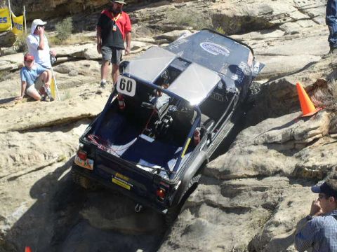 1979 Ford Bronco - An off-road vehicle tackles a challenging rocky course with spectators observing the action.