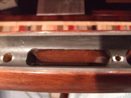 1996 Ford Bronco - Close-up of a wooden trim piece within a metal housing, with visible screw holes.