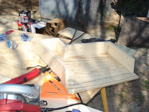 1992 Ford C-350 (Centurion Conversions) - A wooden construction project is shown with various tools and supplies laid out on a table outdoors.