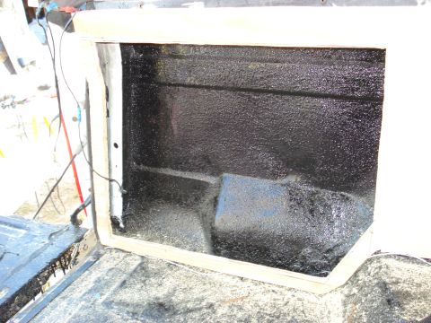 1992 Ford C-350 (Centurion Conversions) - The interior of a truck bed shows a black spray-on liner and a newly installed wooden frame around an opening.