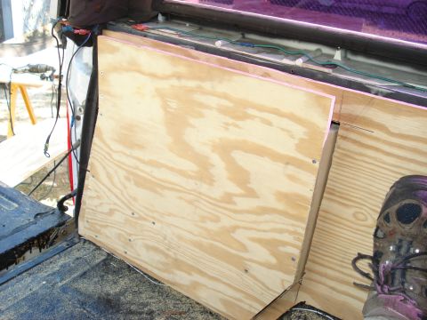 1992 Ford C-350 (Centurion Conversions) - Custom plywood paneling is being installed in the rear cargo area of a vehicle.