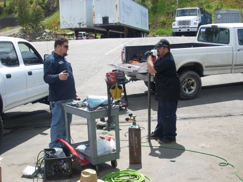 1992 Ford Ranger - Two men are gathered around a welding cart next to a white 1992 Ford Ranger pickup truck.