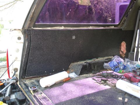 1992 Ford C-350 (Centurion Conversions) - Tools and supplies are visible inside the bed of a truck, which features black textured paneling.