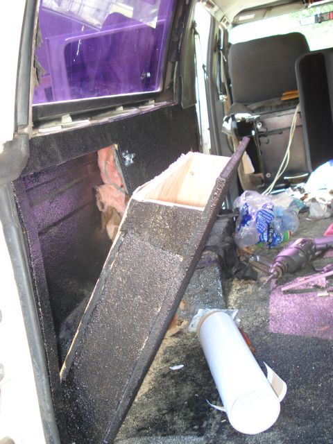 1992 Ford C-350 (Centurion Conversions) - Custom interior modifications in a van, with visible insulation and construction materials, along with tools and trash.