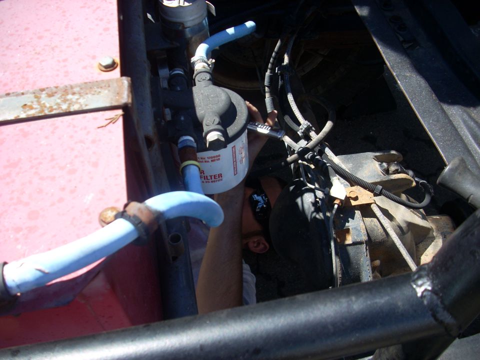 Mechanic working on engine, replacing oil filter