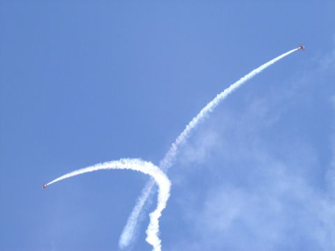 1979 Ford Bronco - Airplanes perform aerobatic maneuvers, leaving trails of smoke in the clear blue sky.