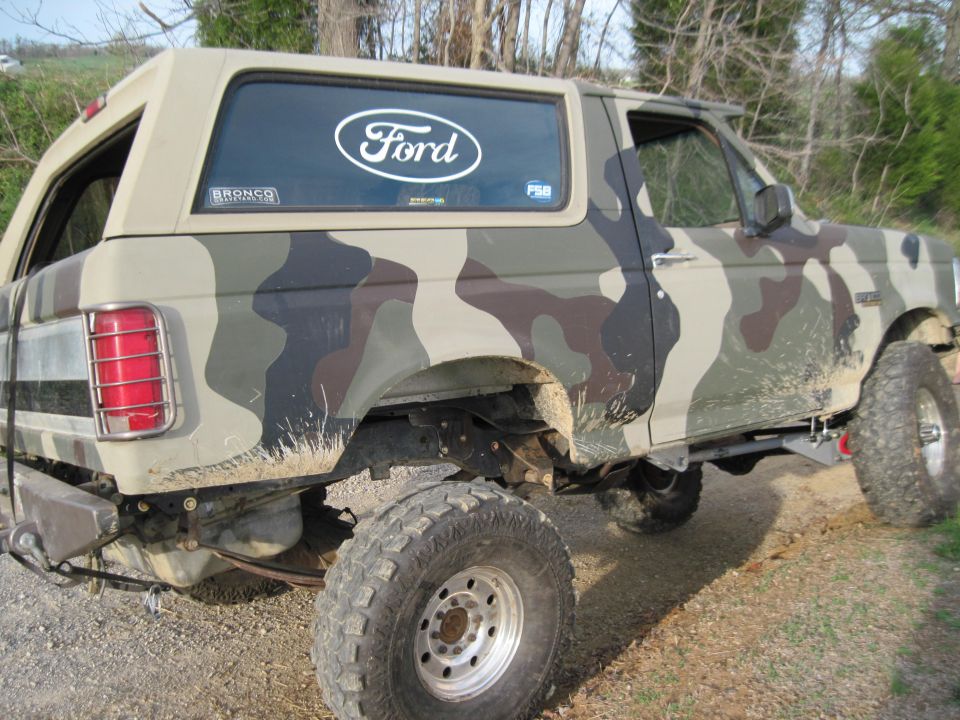 1995 Ford Bronco with camouflage paint, side view. Ford logo on rear window