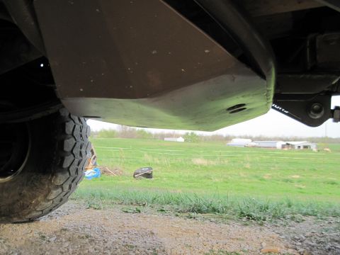 1995 Ford Bronco - This photo shows the underbody skid plate and a portion of the tire of a vehicle.
