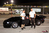 1992 Ford Mustang - Two individuals pose next to a black coupe at what appears to be a nighttime event or race track.