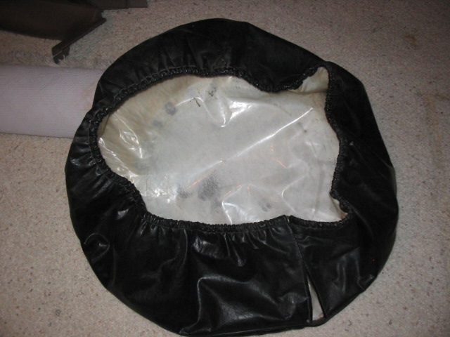 Underside of a black vinyl spare tire cover with elastic band