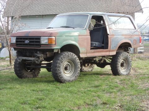 1988 Ford Bronco - This heavily modified 1988 Ford Bronco features a lifted suspension and a unique, weathered paint job.