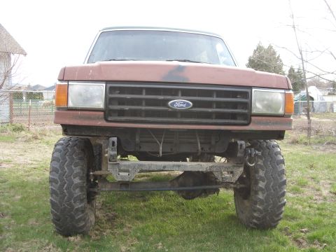 1988 Ford Bronco - Front view of a lifted 1987 Ford Bronco with large off-road tires and a modified bumper.