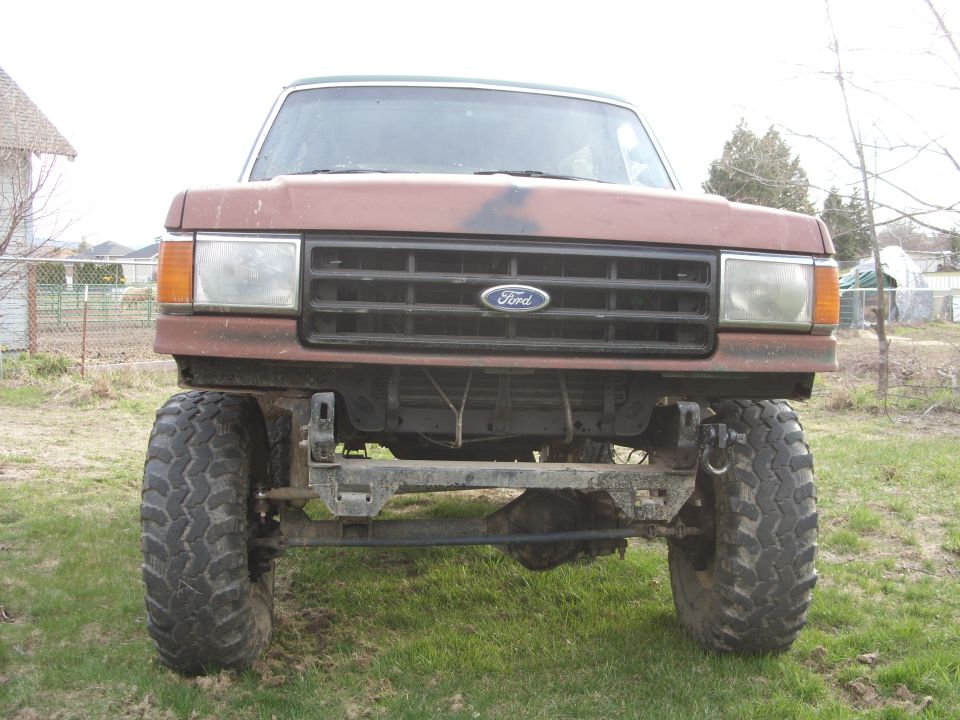 Brown 1987 Ford Bronco front view with large tires and aftermarket bumper