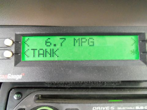 2000 Mercury Grand Marquis - A digital display shows the fuel economy as 6.7 MPG and indicates the fuel tank status.