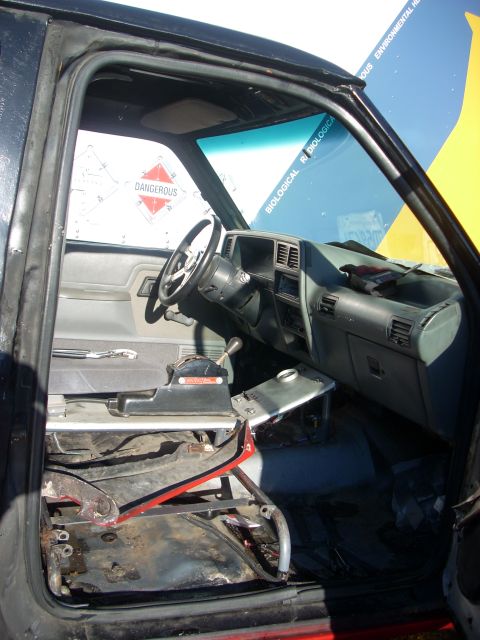 1992 Ford Ranger - The interior of a truck cab is shown with the driver's seat removed and warning labels on the windshield.