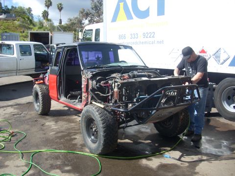 1992 Ford Ranger - A man works on a heavily modified truck with its engine and front end removed, parked next to other vehicles.