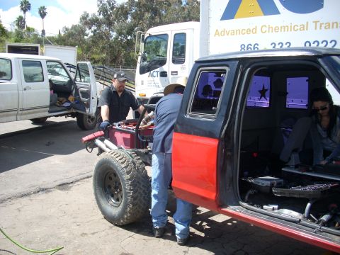 1992 Ford Ranger - Men working on the chassis of a 1992 Ford Ranger, with another truck visible in the background.