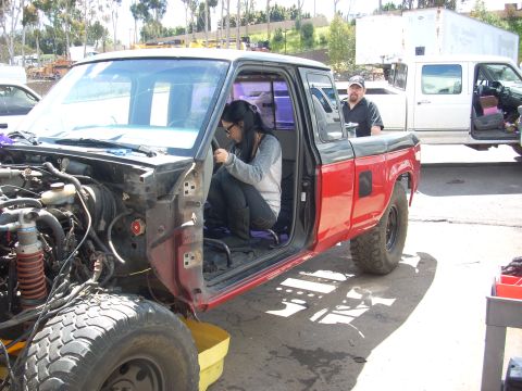 1992 Ford Ranger - A woman works on the interior of a disassembled pickup truck while a man observes.