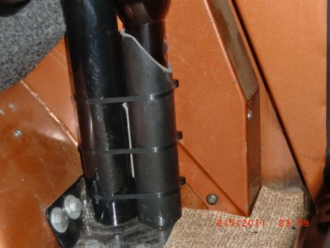 1973 Ford Bronco - Close-up of vehicle interior components, including black tubes and orange paneling.