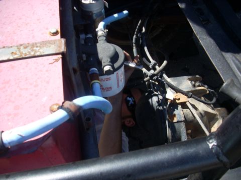 1992 Ford Ranger - A person is shown working on a fuel filter, with part of the engine and truck frame visible.