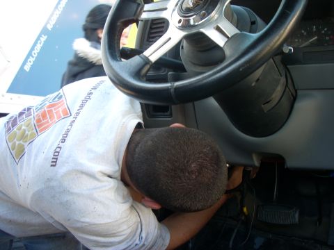 1992 Ford Ranger - A person works on the steering column inside a 1992 Ford Ranger.