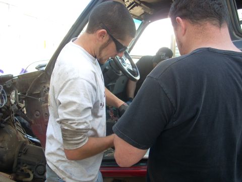 1992 Ford Ranger - Two people are focused on the vehicle's interior wiring, possibly during a repair or modification.