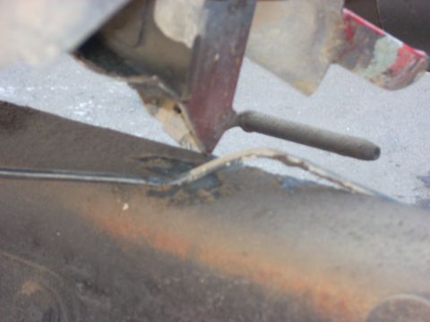 1992 Ford Ranger - This image shows a close-up view of a rusty vehicle frame with some mechanical linkage visible.