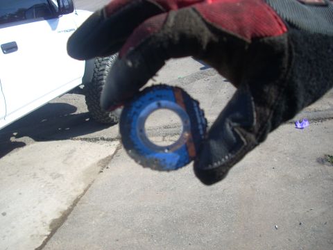 1992 Ford Ranger - A gloved hand holds a worn metal part in front of a white truck.