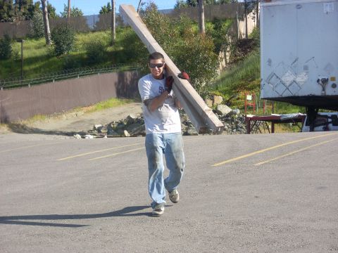 1992 Ford Ranger - Man carrying lumber in a parking lot with a trailer in the background.