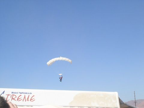 1979 Ford Bronco - A skydiver is captured mid-air under a parachute, with event banners in the foreground.