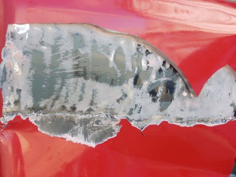 1992 Ford Ranger - Metal repair work in progress on a red vehicle body panel.