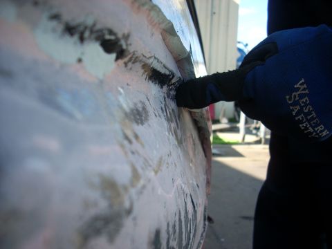 1992 Ford Ranger - Bodywork in progress: scraping filler from a vehicle panel. Western Safety glove is worn.