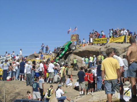 1979 Ford Bronco - Spectators gather to watch an off-road vehicle navigate a challenging rocky incline during an event.
